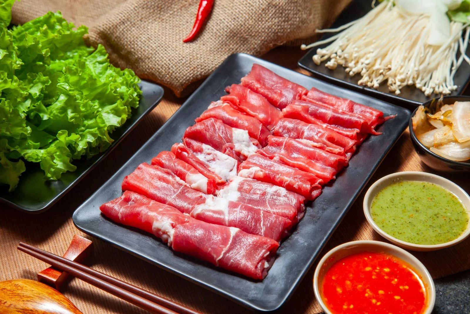 肉や野菜を並べた鍋料理のイメージ