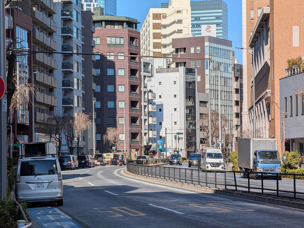 渋谷区の自転車レーン（青い帯）の上に車が止まっている様子