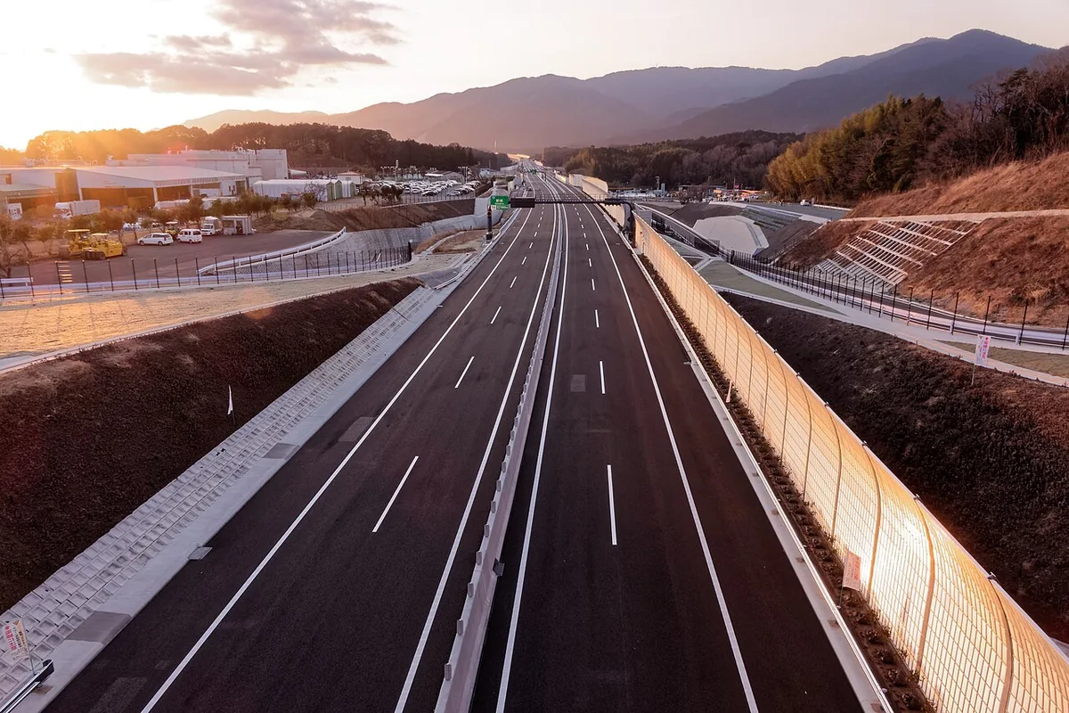 新東名高速道路の新城IC付近。山に囲まれた片側2車線の高速道路が奥へ延びている