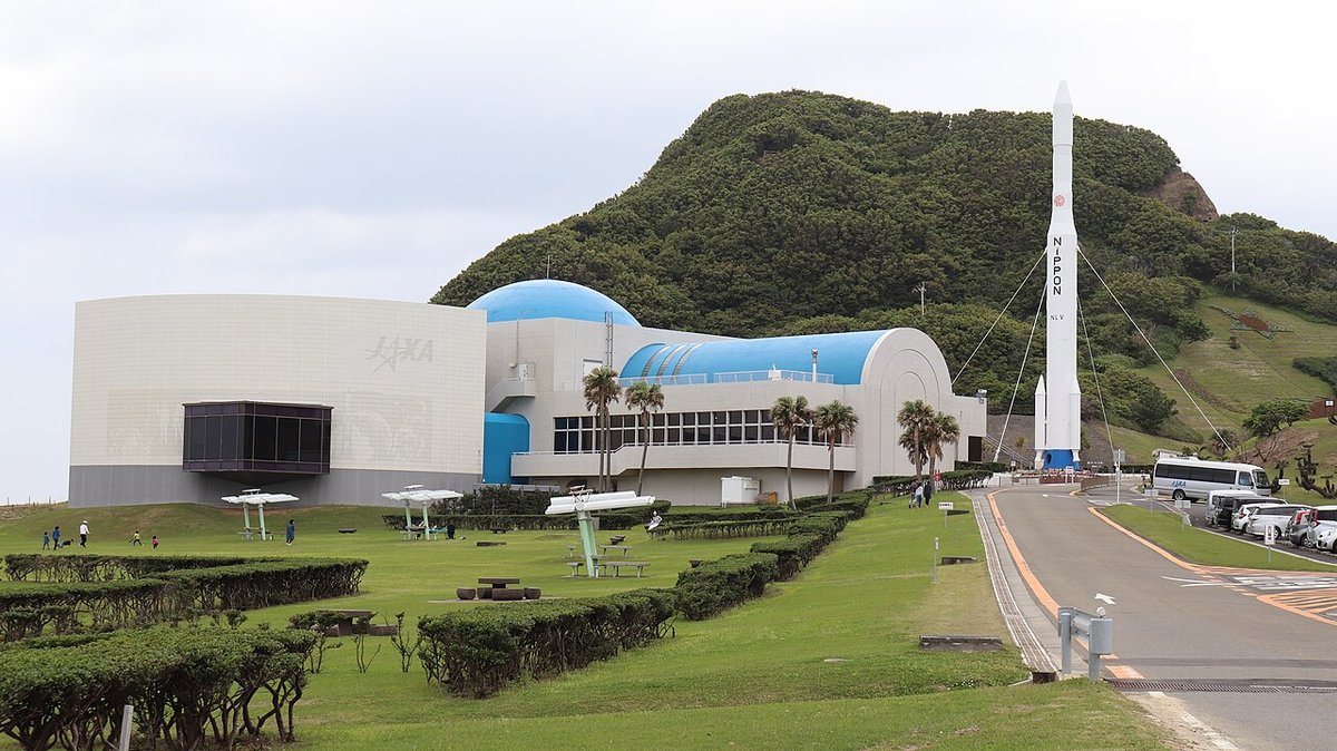 種子島宇宙センターの宇宙科学技術館。青いドームの建物と、ロケットの実物大模型が立つ芝生の広場
