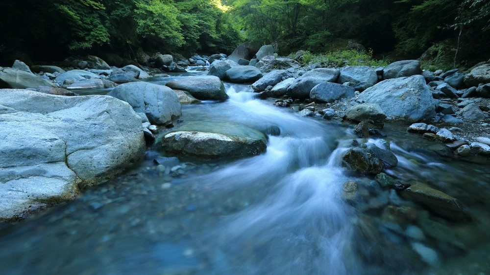 岩の間を水が流れる川のイメージ写真