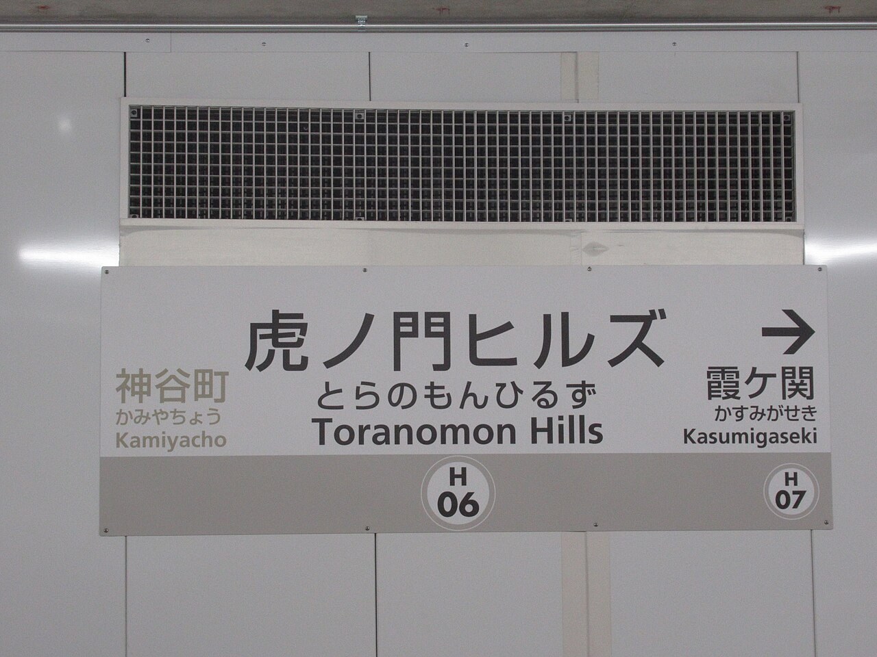 虎ノ門ヒルズ駅の駅名標。左に神谷町、右に霞ケ関と書かれている