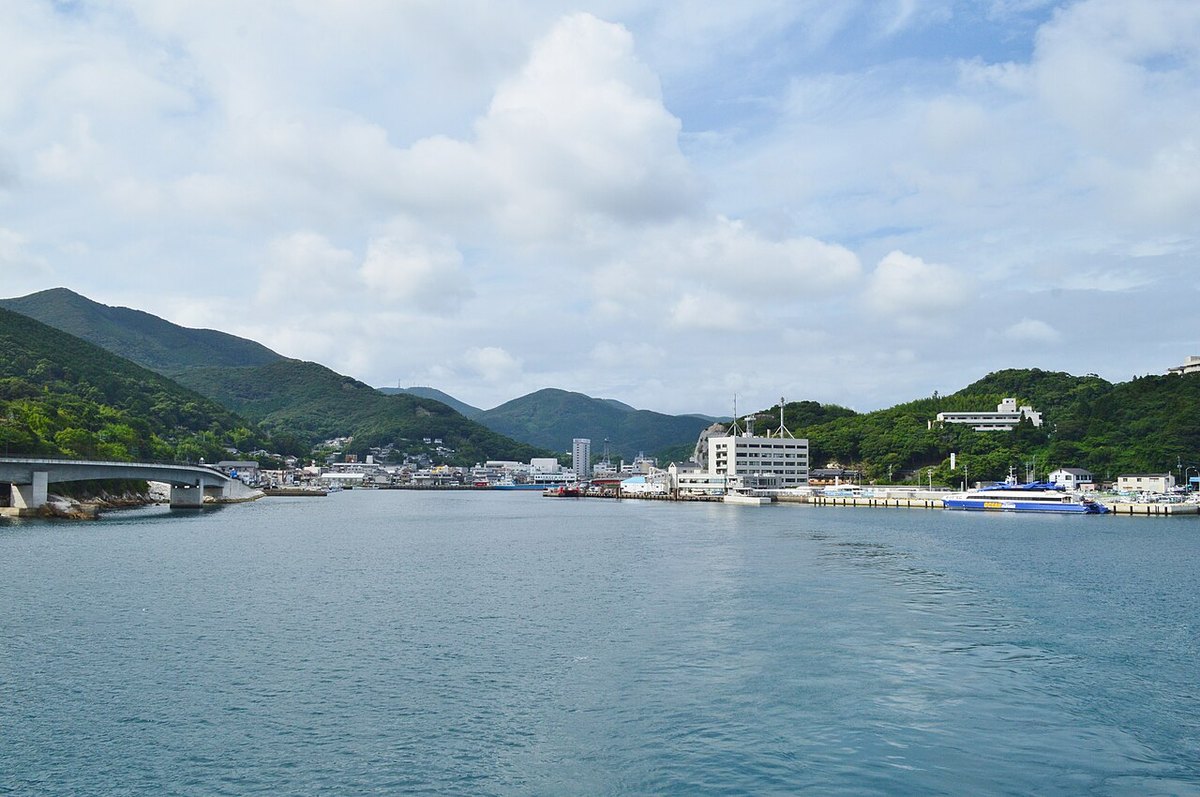 長崎県対馬市の厳原港。山に囲まれた湾に市街地とフェリーが見える