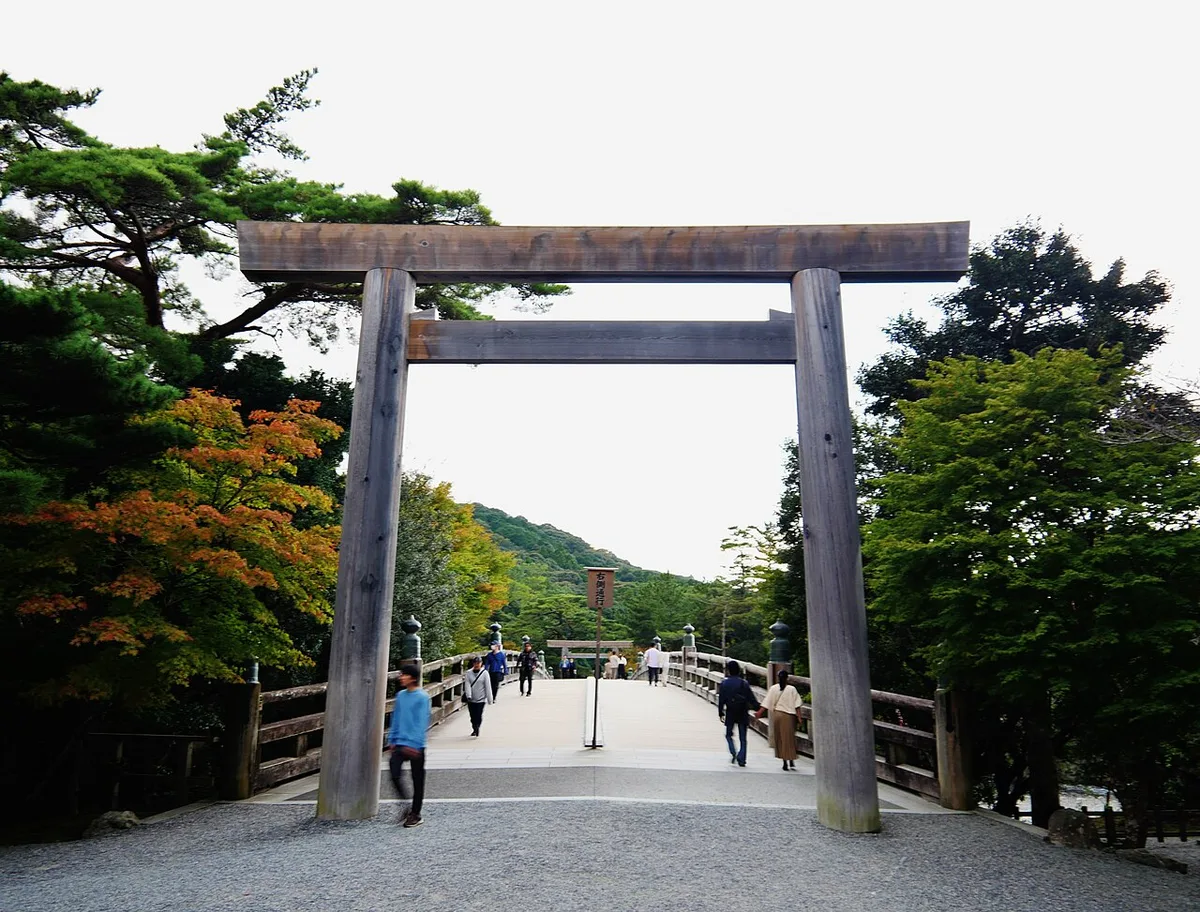伊勢神宮内宮の宇治橋の手前に立つ木の鳥居。鳥居の奥に宇治橋がのびている