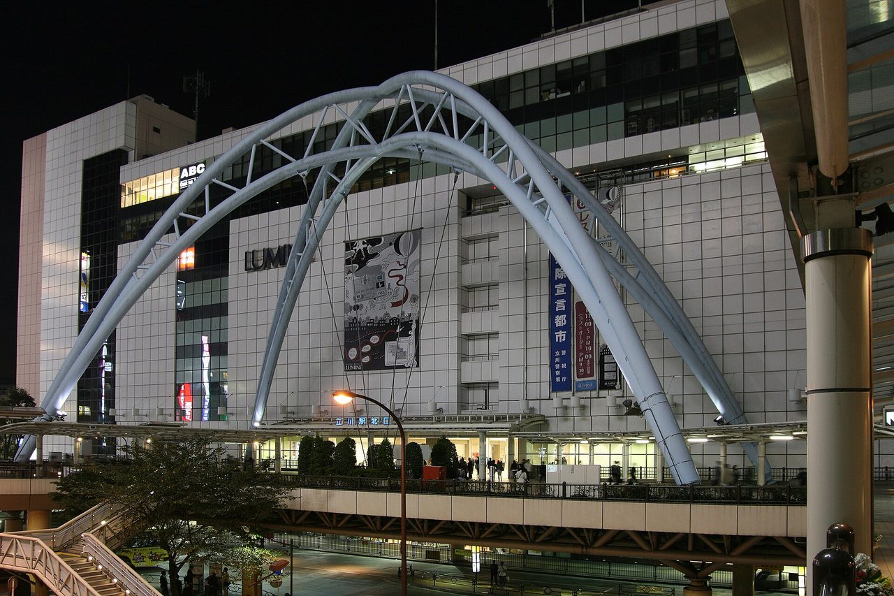 夜の立川駅北口。白いアーチの下にペデストリアンデッキが広がる